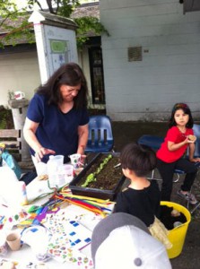 PosAbilities' Karen Cusmano helps children plant sunflower seeds.