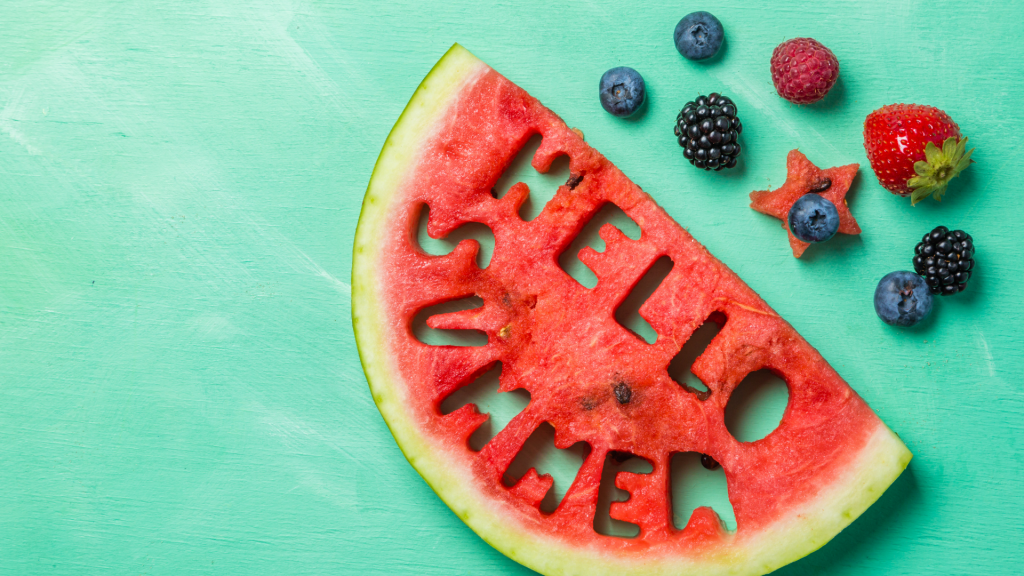 A watermelon slice with the words "HELLO SUMMER" carved into it