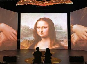 Silhouette of two people in a museum looking at a display of the Mona Lisa